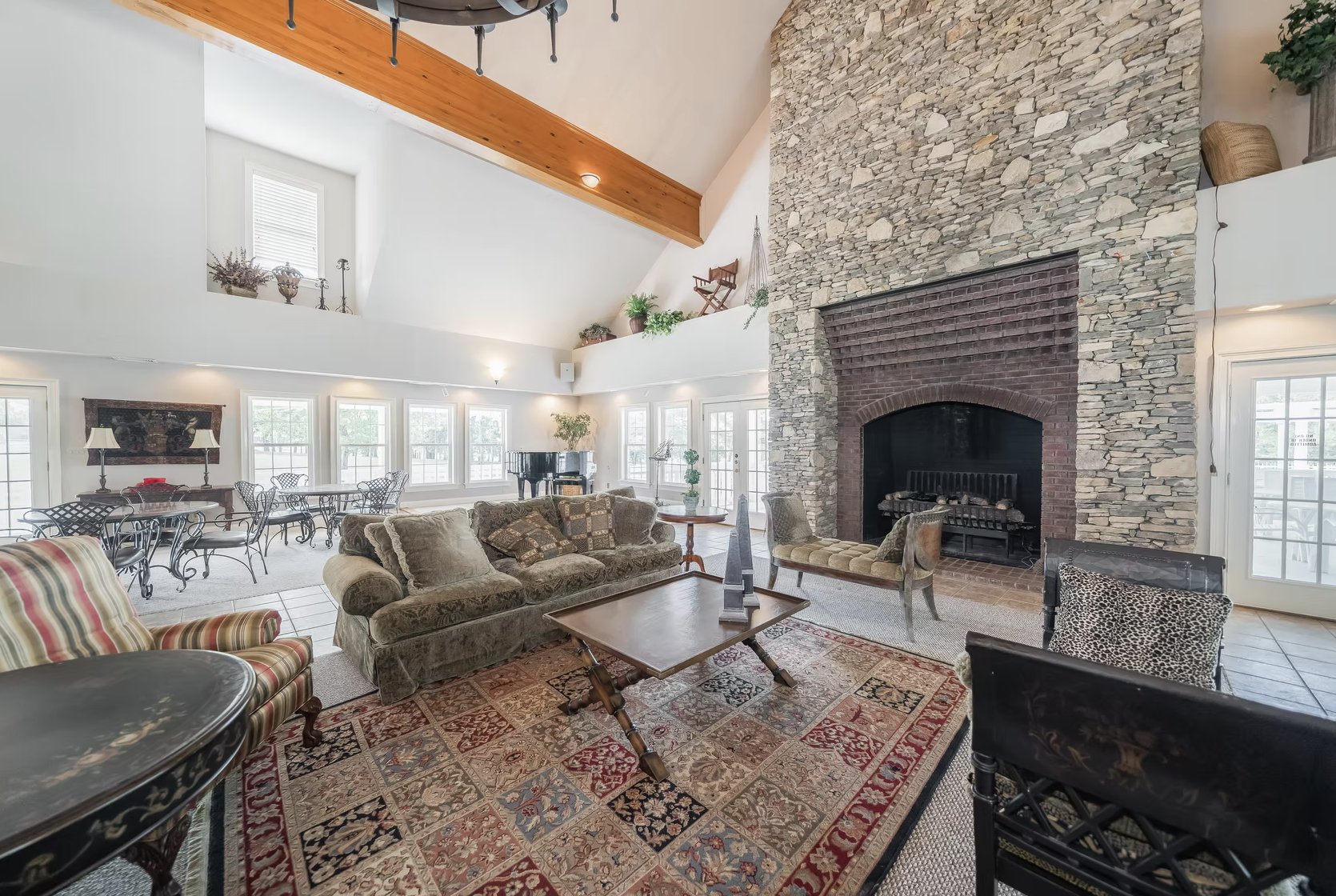 The lodge gathering space with seating and a stone fireplace.